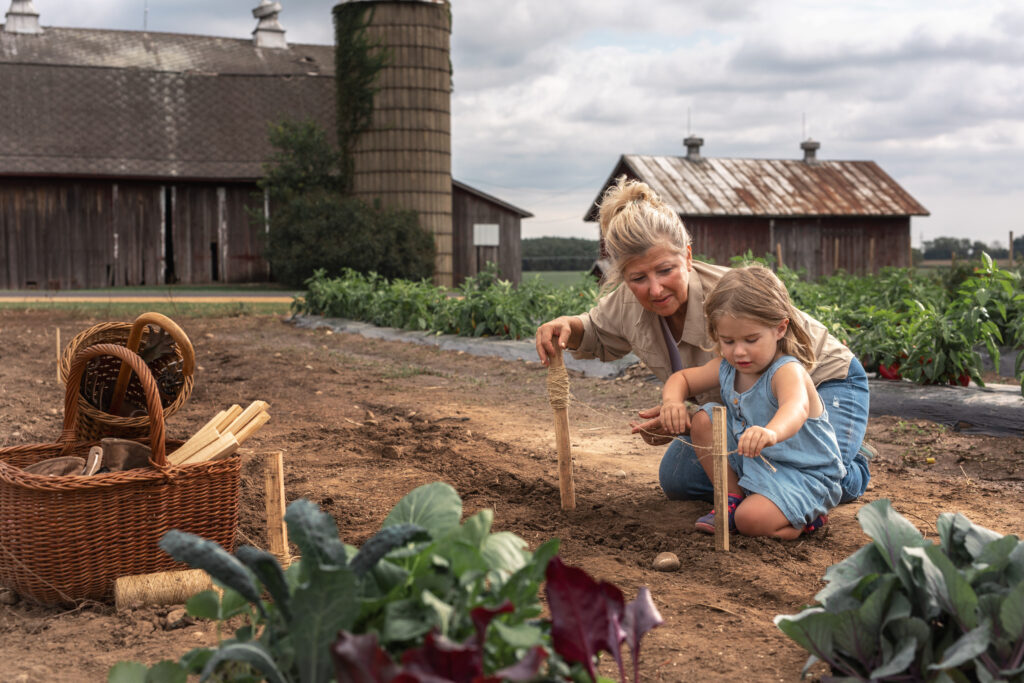 Grandmother kneeling in garden with grandaughter